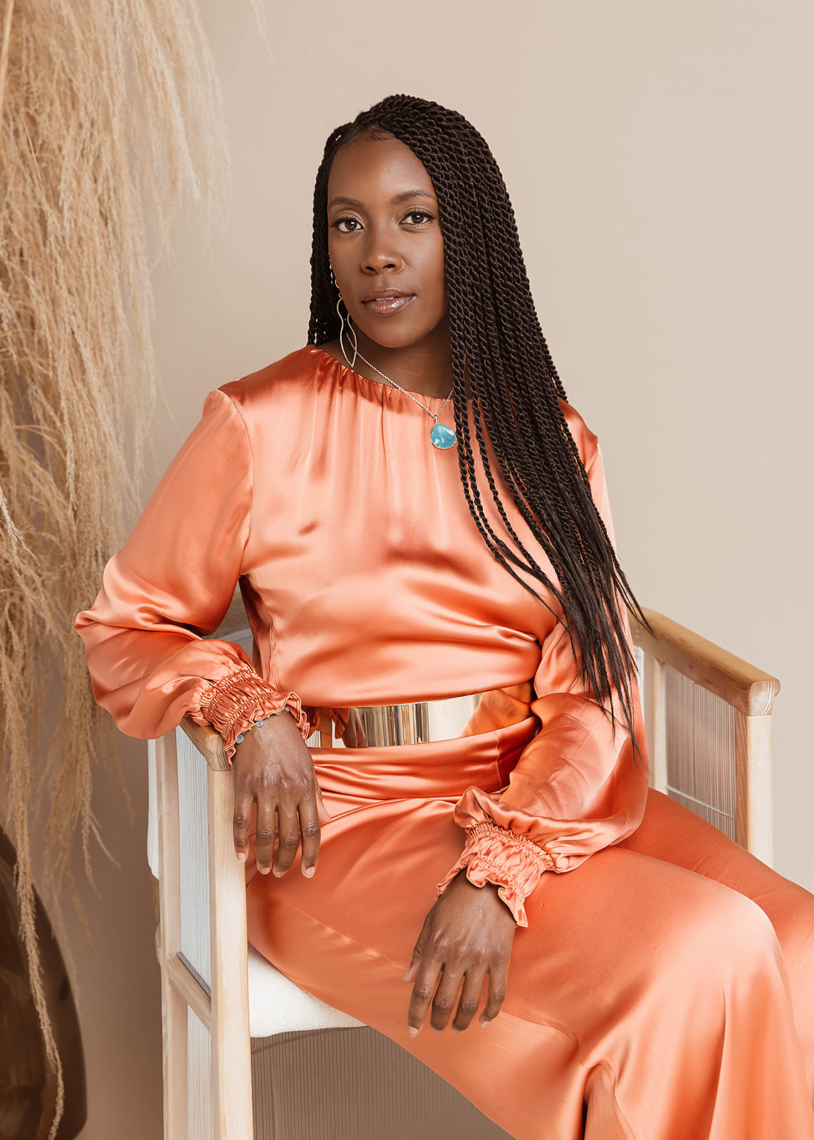 Ama McKinley seated in an orange dress